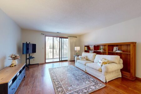 Bright living room with hardwood flooring and area rug showcasing natural wood floor installation in a modern home interior