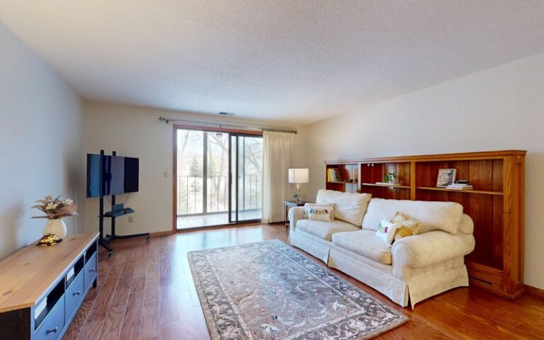 Bright living room with hardwood flooring and area rug showcasing natural wood floor installation in a modern home interior