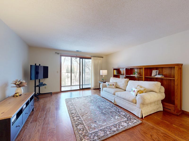 Bright living room with hardwood flooring and area rug showcasing natural wood floor installation in a modern home interior